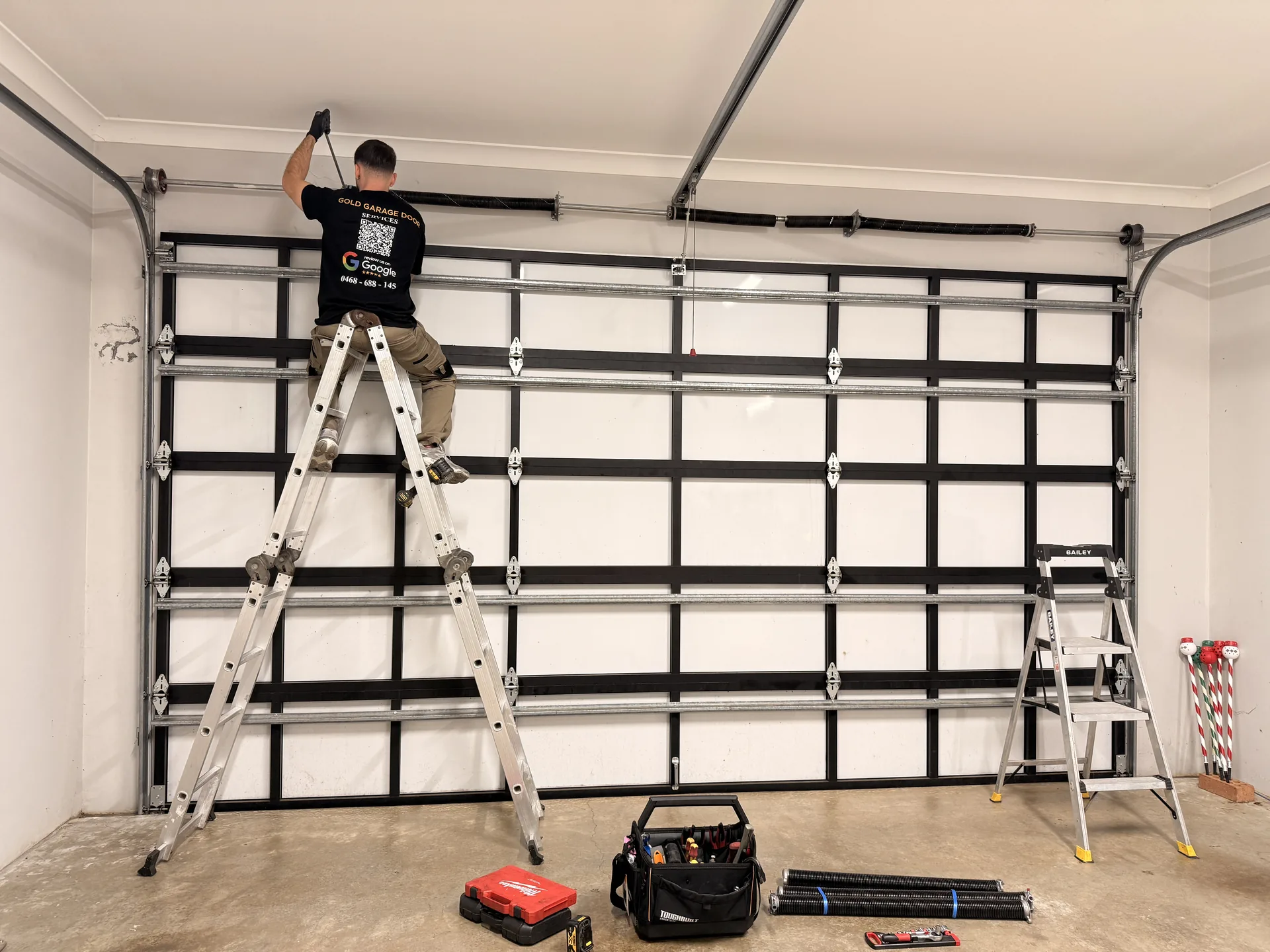 Gold Garage Door technician repairing a garage door spring in Sydney